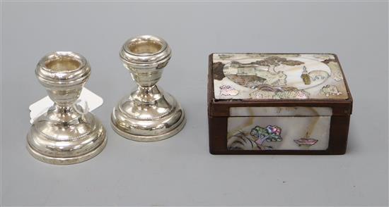 A mother of pearl snuff box and a pair of silver dwarf candlesticks